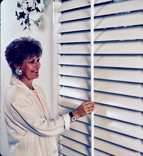 Woman Adjusting The Window Blinds